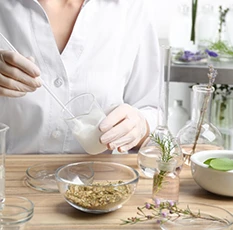 Chercheuse en blouse blanche mélangeant un ingrédient cosmétique avec des extraits végétaux dans un laboratoire ITERG