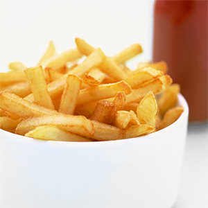 Gros plan sur des frites croustillantes assaisonnées, avec une légère touche d’herbes.