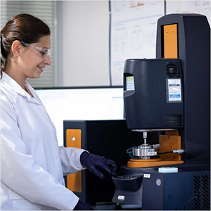 Technicienne de laboratoire utilisant un rhéomètre pour analyser les propriétés viscoélastiques d’un échantillon."