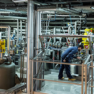 Ingénieur dans une usine industrielle-ALLIANCE Technicien inspectant une cuve au sein d’une installation industrielle complexe.