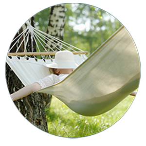 Jours de repos Personne détendue dans un hamac à l’ombre des arbres.