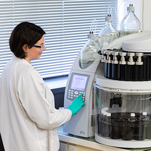 Recherche sur automate de laboratoire-ALLIANCE Scientifique en blouse blanche utilisant un appareil automatisé pour des analyses en laboratoire