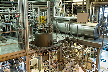 : Vue d’un atelier industriel avec équipements en inox dédiés à la chimie du végétal, extraction ou formulation à l’échelle pilote.</p>
<p>