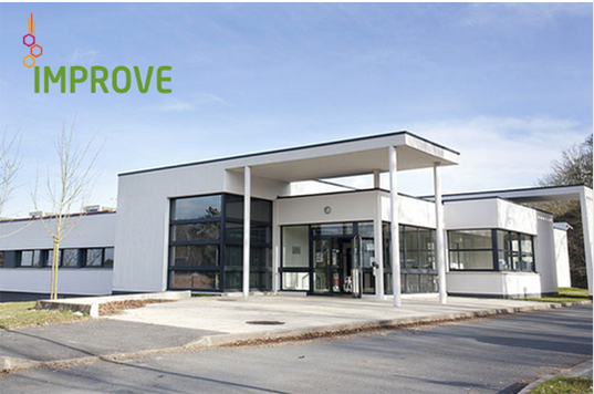 ntrée du bâtiment d’IMPROVE, centre d’expertise en protéines végétales, avec architecture moderne blanche et logo en haut à gauche.