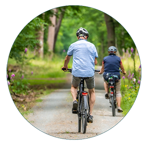 indemnité vélo Deux personnes faisant du vélo sur une piste cyclable en pleine nature.