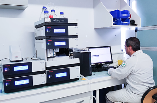  Chercheurs en blouse blanche travaillant dans un laboratoire moderne équipé, avec une scientifique manipulant un appareil analytique à l'avant-plan.</p>
<p>