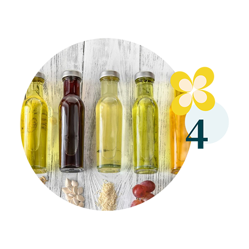 valeurs 4 Alignement de flacons d’huiles végétales de différentes couleurs posés sur une table en bois blanc, avec leurs graines ou fruits d’origine en dessous, et un motif floral jaune avec le chiffre 4 à droite.<br />